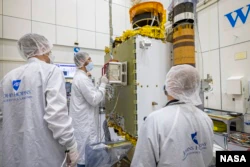 Mitglieder des DART-Teams vom Johns Hopkins Laboratory of Applied Physics in Maryland und der Italian Space Agency positionierten den LICIACube sorgfältig auf dem DART-Raumschiff.  (Bildnachweis: NASA/Johns Hopkins APL/Ed Whitman)