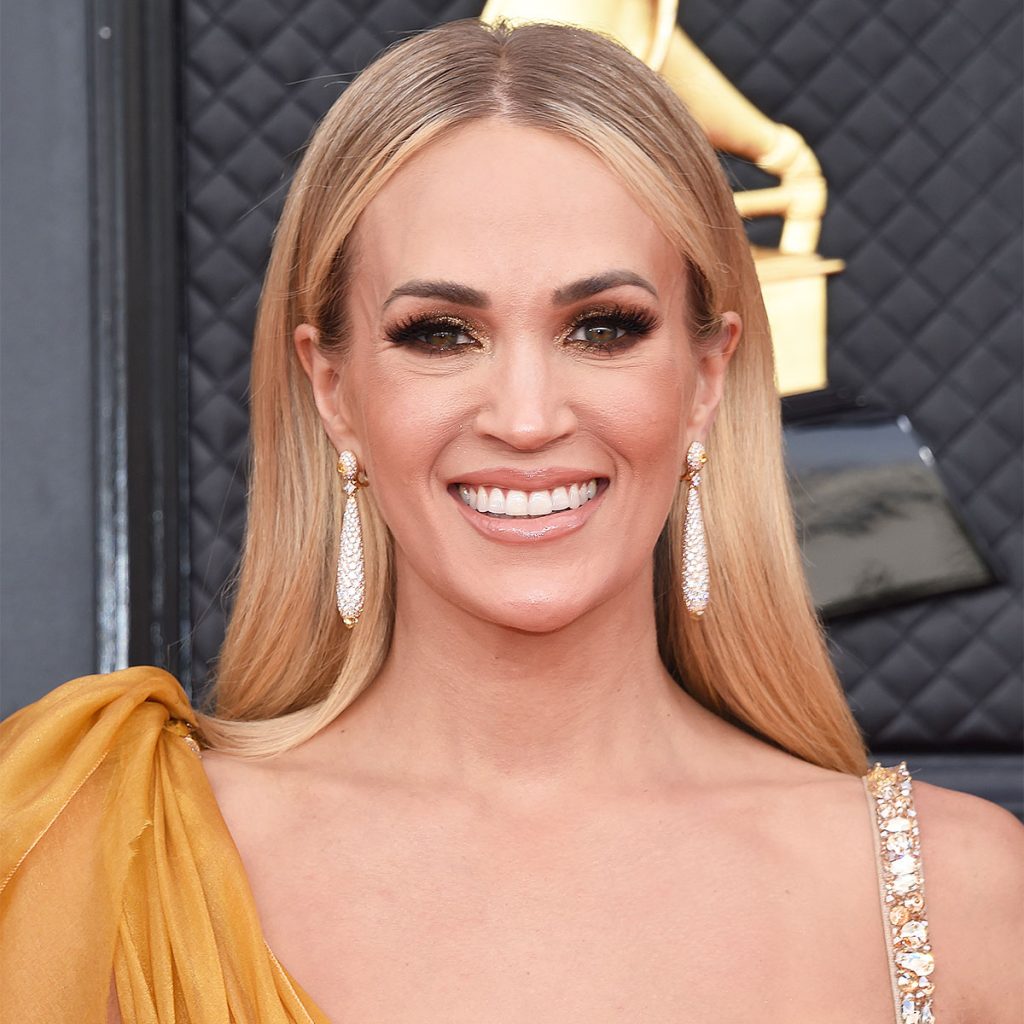 Carrie Underwood beweist, dass ihre Arme genauso ebenbürtig sind wie ihre Beine, als sie in einem weißen Tanktop und Strass-Shorts zum Schlagzeug abhebt.