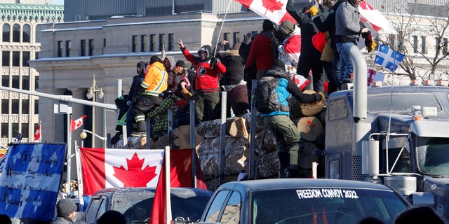 DATEIFOTO: Demonstranten stehen auf einem Anhänger mit Baumstämmen, während LKW-Fahrer und Unterstützer an einem Konvoi teilnehmen, um gegen Mandate für einen Coronavirus (COVID-19)-Impfstoff für grenzüberschreitende LKW-Fahrer in Ottawa, Ontario, Kanada, am 29. Januar 2022 zu protestieren. REUTERS/PATRICK DOYLE/DATEI Bild