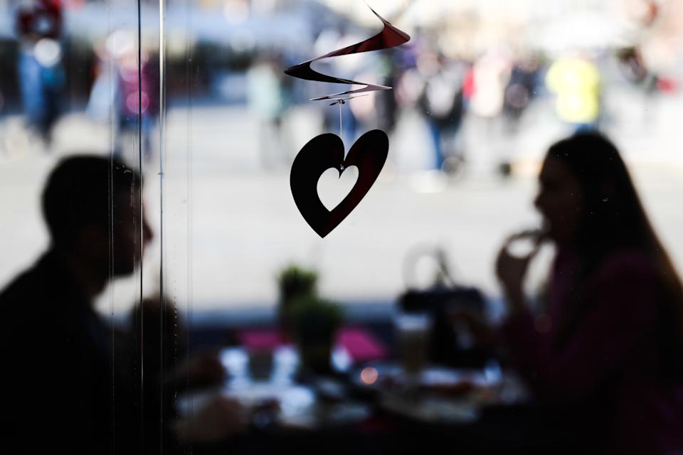 Herzförmige Dekoration und ein Paar, das am Tisch im Restaurant sitzt, am Tag vor dem Valentinstag, in Krakau, Polen, am 13. Februar 2022 (Foto von Jacob Borzeki/Noor Photo via Getty Images)