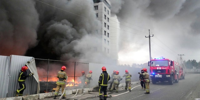Feuerwehrleute arbeiten daran, nach dem Bombenanschlag auf Kiew, Ukraine, am Donnerstag, den 3. März 2022, ein Feuer in einem beschädigten Logistikzentrum zu löschen. Russische Streitkräfte haben die Angriffe auf überfüllte Städte verstärkt, was der ukrainische Führer als offensichtliche Terrorkampagne bezeichnete. 