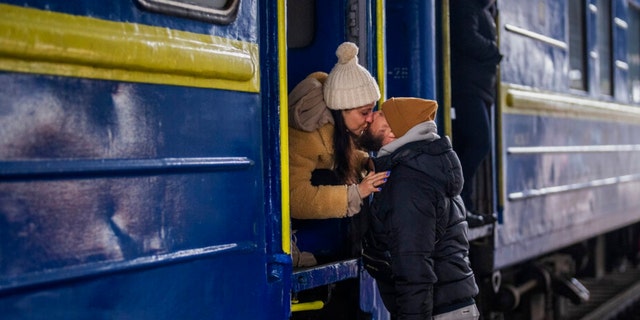 Stanislav, 40, küsst seine Frau Anna, 35, in einem Zug nach Lemberg, als sie sich am Donnerstag, dem 3. März, am Bahnhof von Kiew in der Ukraine verabschieden.  2022. Stanislav wird bleiben, um zu kämpfen, während seine Familie das Land verlässt, um in einem Nachbarland Zuflucht zu suchen.