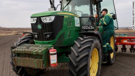 Der ukrainische Landwirt Morda Vasyl betritt die Traktorkabine von John Deere.