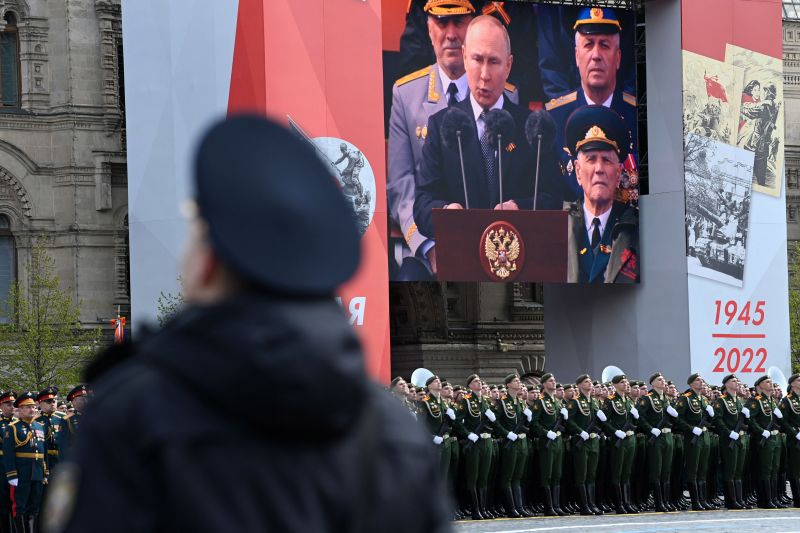 Ein Bildschirm zeigt den russischen Präsidenten Wladimir Putin, der während der Militärparade zum Tag des Sieges in Moskau am 9. Mai eine Rede hält, während Soldaten den Roten Platz säumen.