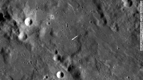 Der neue Krater ist kleiner als der andere Krater und in dieser Ansicht nicht sichtbar, aber seine Position wird durch den weißen Pfeil angezeigt. 