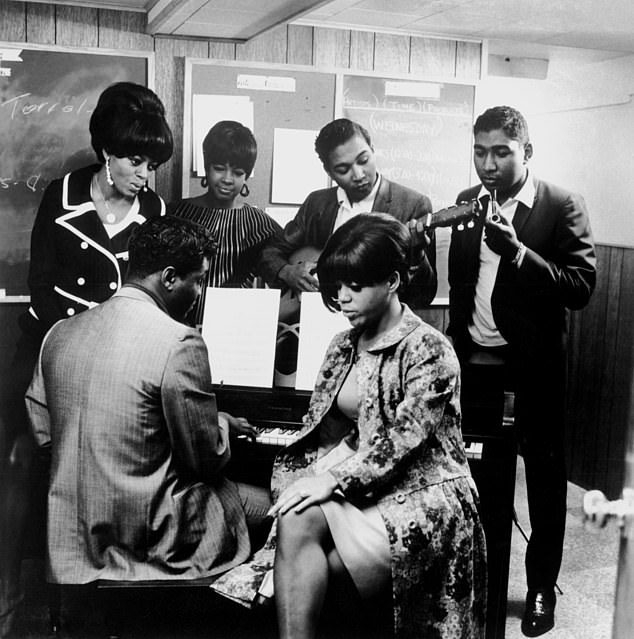 Das Foto zeigt von links nach rechts Diana Ross, Lamont Dozier (am Klavier), Mary Wilson, Eddie Holland, Florence Ballard (sitzend) und Brian Holland im Motown-Studio um 1965 in Detroit