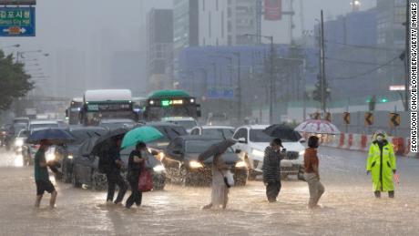 Fußgänger überqueren am 9. August eine überflutete Straße in Gimpo, Seoul.