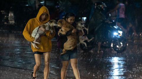 Bewohner tragen am 25. September ihre Haustiere in ein Evakuierungszentrum inmitten von starkem Regen in Marikina City, einem Vorort von Manila, Philippinen.