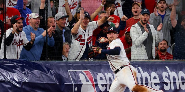 Austin Riley #27 der Atlanta Braves wirft den Ball, nachdem er im achten Inning des zweiten Spiels der National League Series im Troist Park am 12. Oktober 2022 in Atlanta, Georgia, gegen die Philadelphia Phillies angetreten ist.