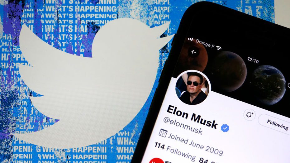 Der Twitter-Account von Elon Musk wird auf dem iPhone-Bildschirm vor der Startseite der Twitter-Website angezeigt