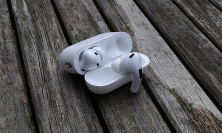 AirPods Pro 2-Hülle offen auf einem Tisch mit einem Ohrhörer, der an der Abdeckung hängt.