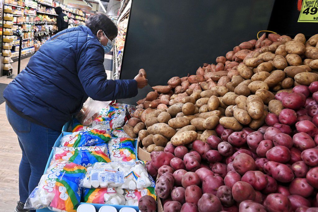 Eine Frau verteilt Kartoffeln in einem Lebensmittelgeschäft.