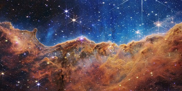 Was an einem mondhellen Abend sehr wie felsige Berge aussieht, ist tatsächlich der Rand der nahe gelegenen, jungen Sternentstehungsregion NGC 3324 im Carinanebel.  Dieses Bild, das von der Nahinfrarotkamera (NIRCam) des James-Webb-Weltraumteleskops der NASA im Infrarotlicht aufgenommen wurde, enthüllt zuvor verdeckte Regionen der Sternentstehung.